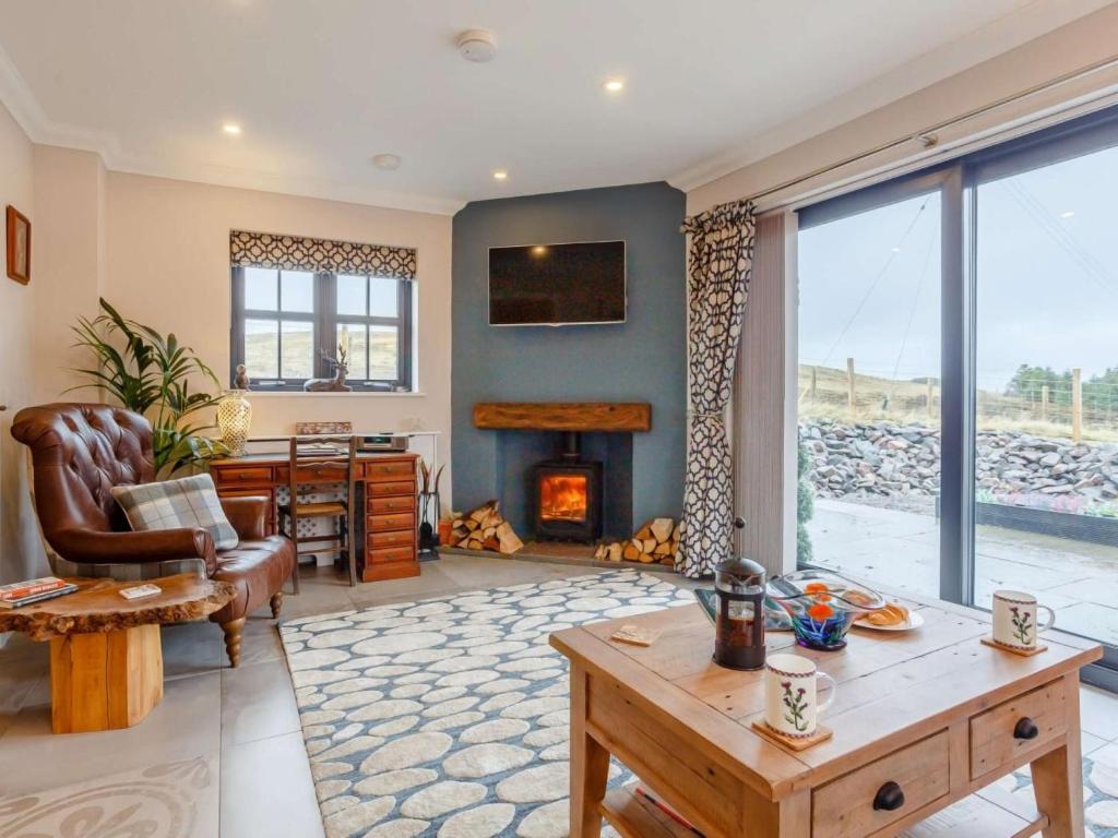 a living room with a fireplace and a table at 2 Bed in Lairg oc-86104 in Durness