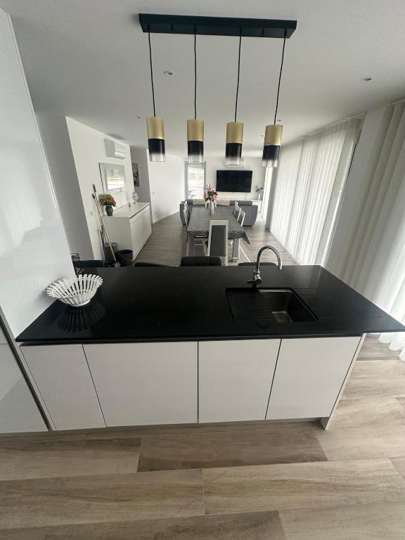 a kitchen with a sink and a living room at Apartamento B T4 Pombal in Pombal