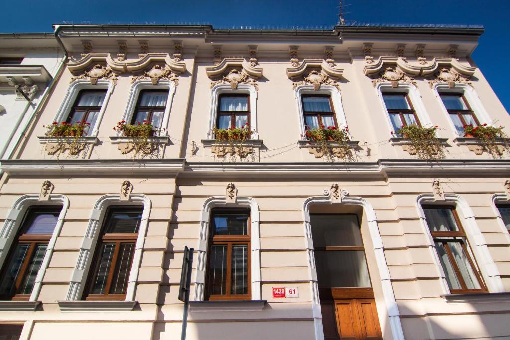 un edificio con ventanas y cajas de flores. en Apartmány - Penzion Smetanka, en České Budějovice