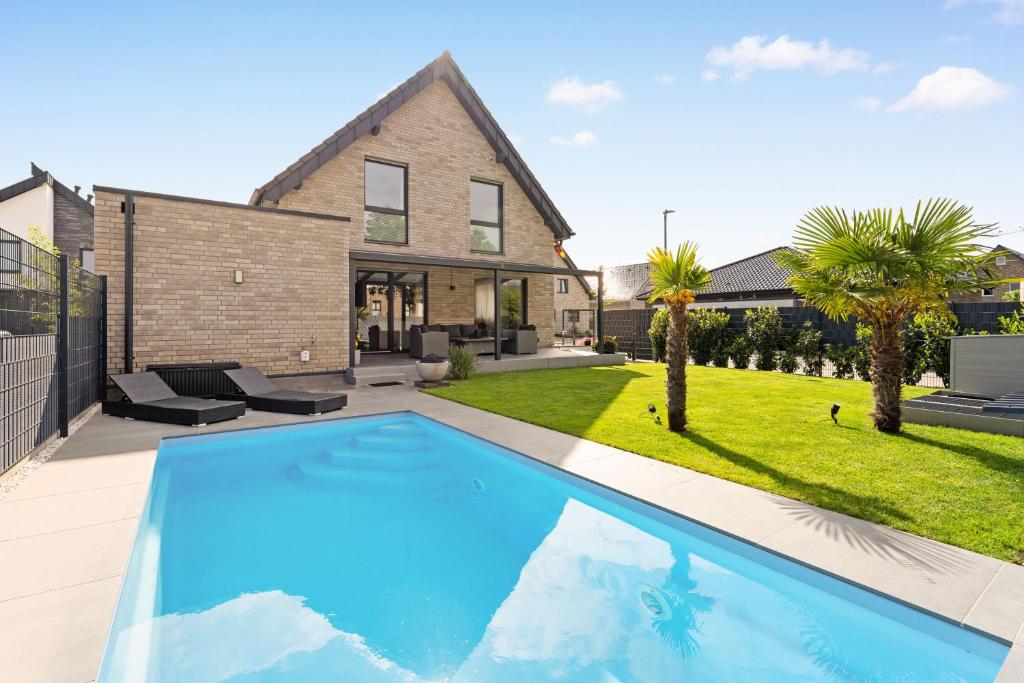 a swimming pool in the backyard of a house at Modo Apartment in Erkelenz mit Sauna Pool in Erkelenz