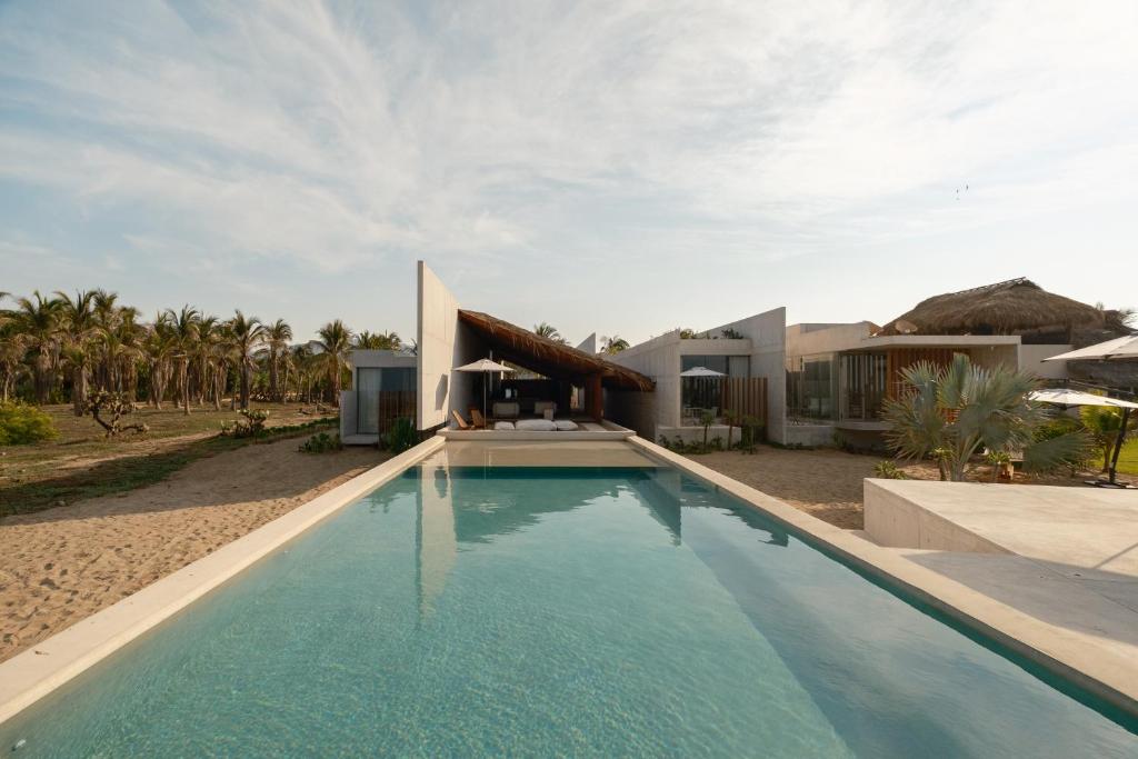 a swimming pool in front of a house at Casa Talá by Lumina in Puerto Escondido