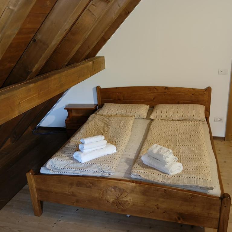 two beds with towels on them in a attic at Stanza Cuori Malga Ciauta in Villanova