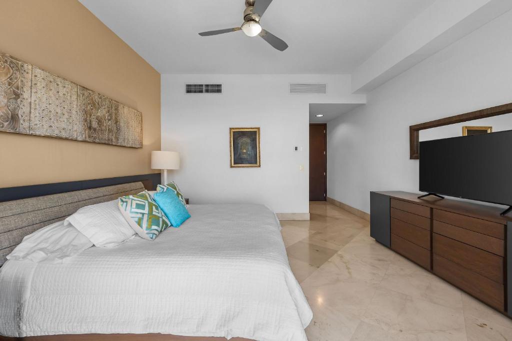 a bedroom with a bed and a flat screen tv at Luxury Beach Condo with Resort Access Vidanta in Nuevo Vallarta