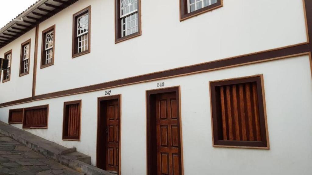 a white building with wooden doors and windows at Casa da Ópera in Diamantina