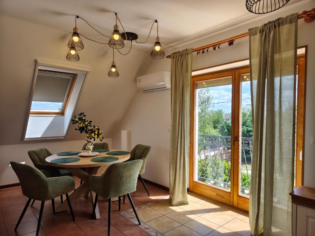 a dining room with a table and chairs and a window at Salvia Guesthouse Balatonfüred in Balatonfüred