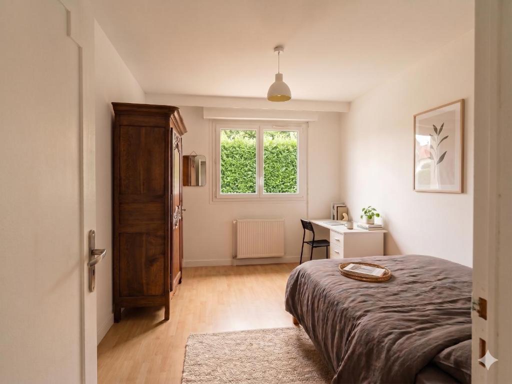 a bedroom with a bed and a window and a desk at Ecolocs Caen Beuville in Caen