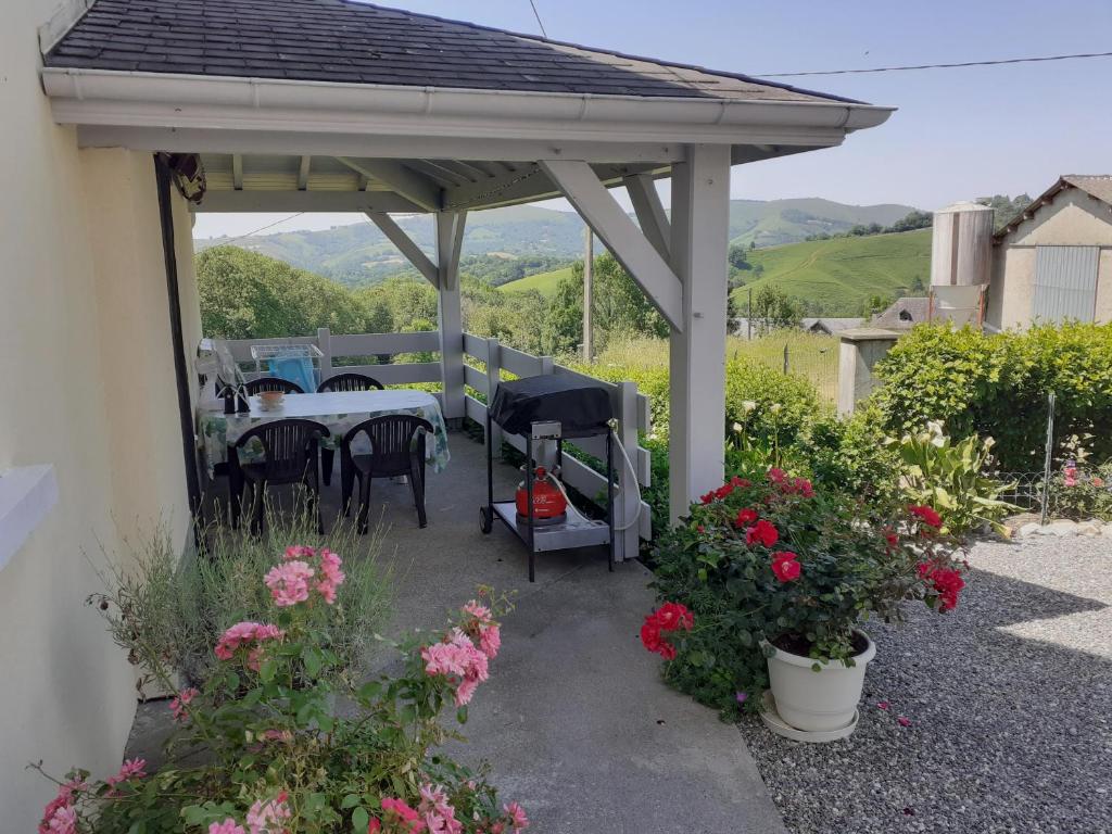 a pavilion with a table and chairs and flowers at Gite au pied de la montagne avec tous commerces in Arette