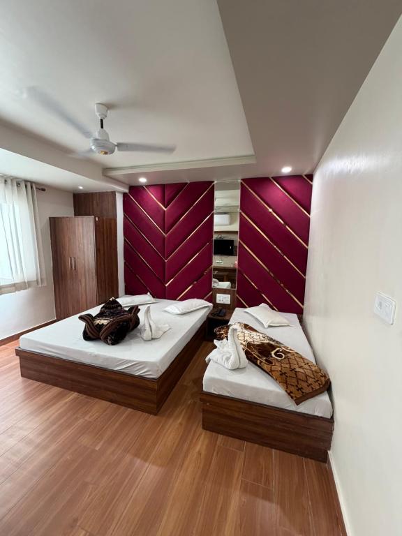 two beds in a room with purple walls at Hotel Royal Suites in Ajmer