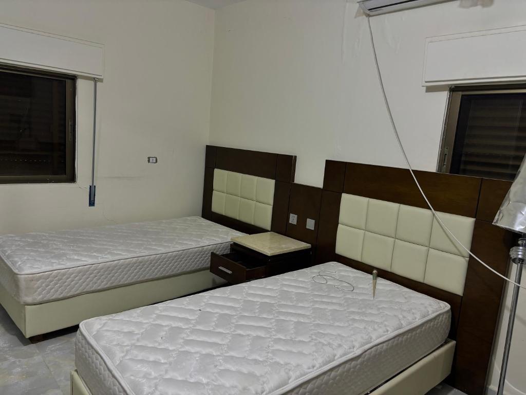 a bedroom with two beds and a window at Ahmmad in Şirfah