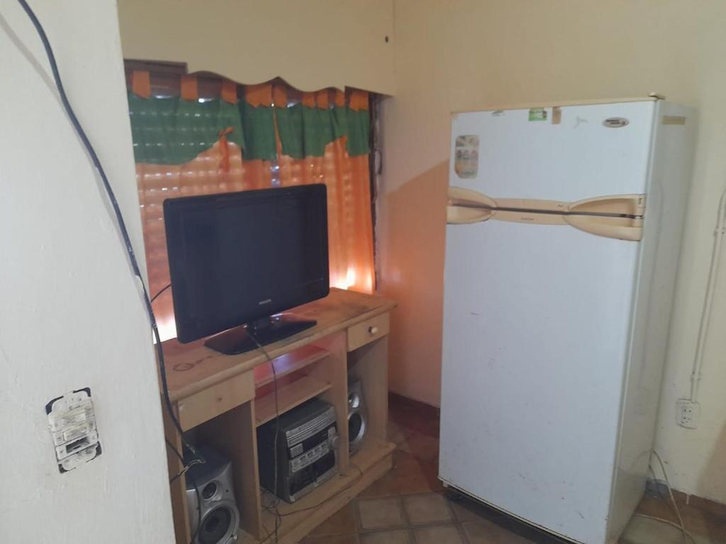 a small kitchen with a refrigerator and a television at Ruca in Bragado