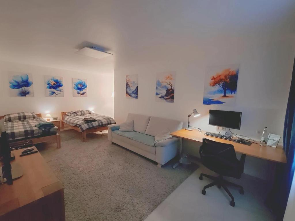 a room with a desk with a computer and a couch at Gästezimmer La Siesta in Ötisheim