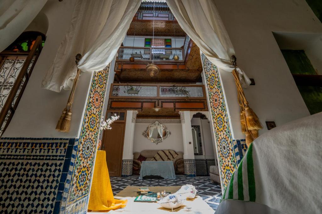 a living room with a table and curtains at Riad Lik in Fez