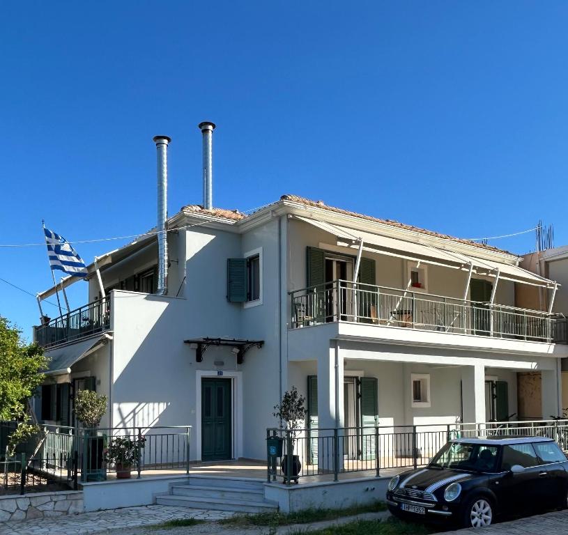 a white house with a car parked in front of it at Thermos House Nydri in Nydri