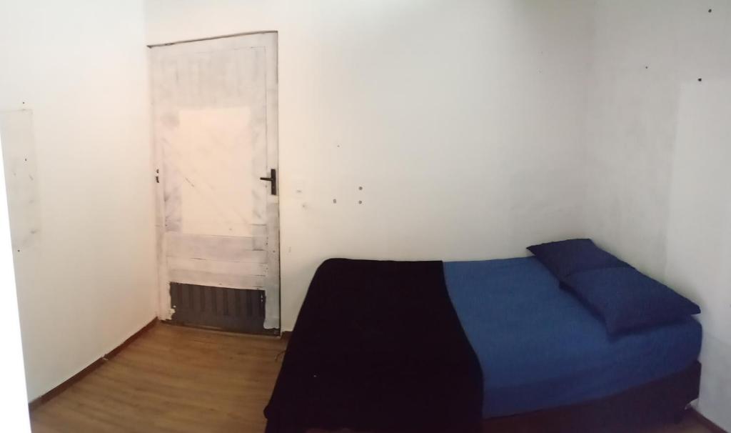 a bedroom with a blue bed and an open door at Pousada Marlin in Dois Vizinhos