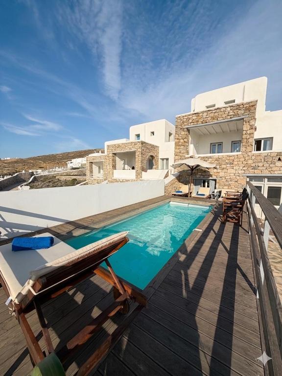 a swimming pool in front of a villa at Parfait Villa, Mykonos in Agios Ioannis Mykonos