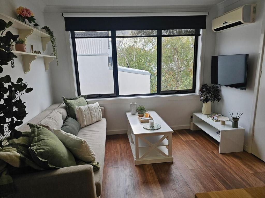 a living room with a couch and a table at Richmond apartment close to MCG in Melbourne