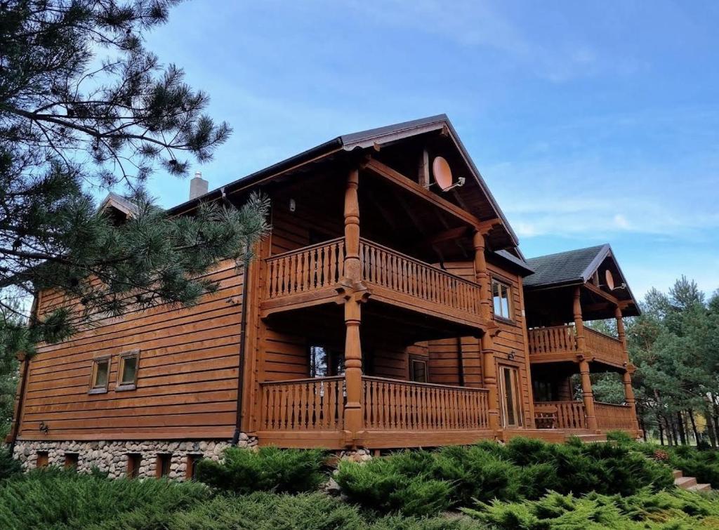 a large wooden house with a large deck at Brižių sodyba in Brižiai