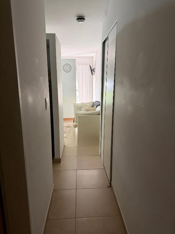 a hallway with a door to a room with a couch at Depto Céntrico cq in Bahía Blanca