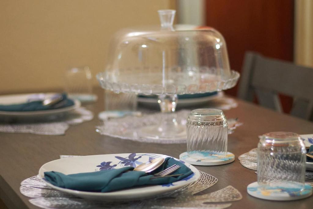 a wooden table with plates and glasses on it at An-Garo Ko-Zy Spaces in Saint Johnʼs