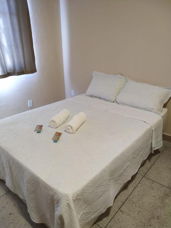 a white bed with two towels on top of it at Loft Campinho 3 in Estação Inhoaíba