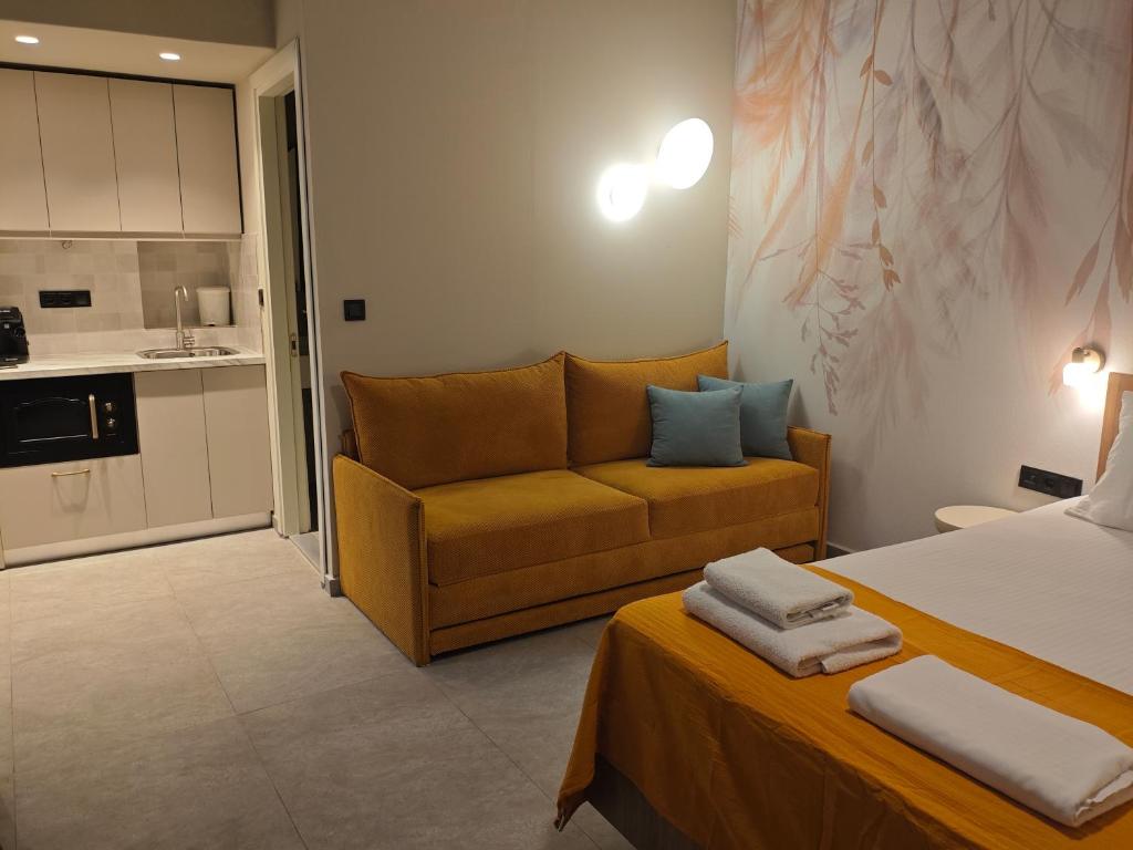 a room with a bed and a couch and a kitchen at Aggeliki Apartment in Skiathos