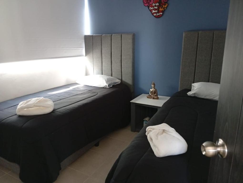 a bedroom with two beds with white pillows at Habibi Cocoyoc in Cocoyoc