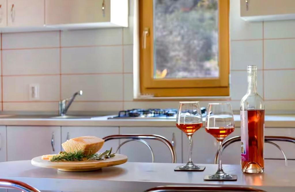 two glasses of wine sitting on a kitchen table at Villa Olive in Dol