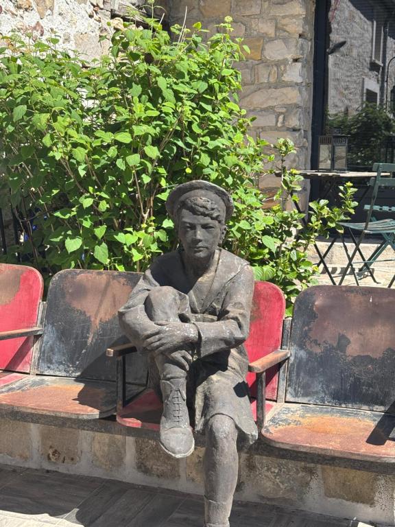 a statue of a man sitting on a bench at La Vieille Demeure in Barbizon