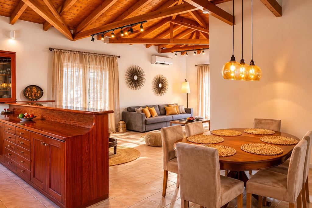 a kitchen and living room with a wooden table and chairs at Niobe Luxury Residence in Loutraki