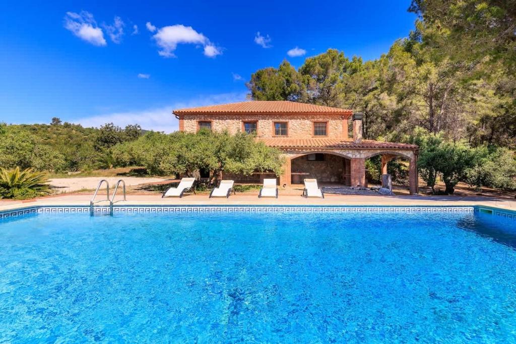 a house with a swimming pool in front of a house at Masia Garriga in Tarragona