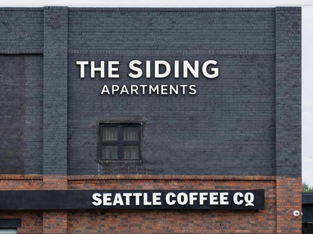 a sign on the side of a brick building at The Siding Apartments in Hilton