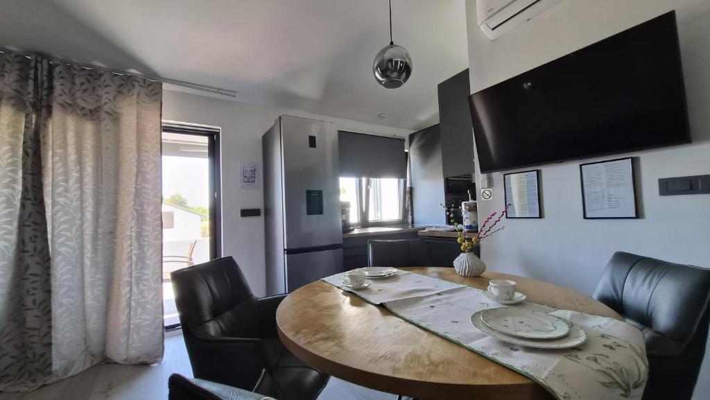 a dining room with a wooden table and black chairs at Innova TravelVir - Salt and Sun in Vir