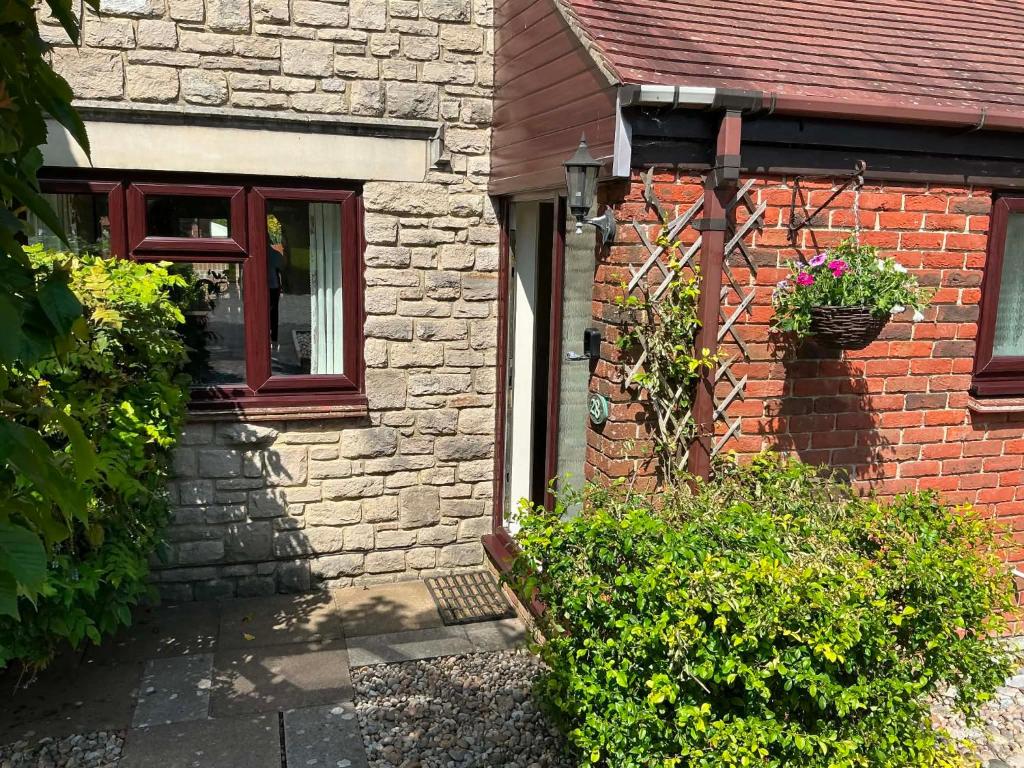 a brick house with a window and a potted plant at 3 bed house in Winterbourne Abbas in Winterborne Abbas