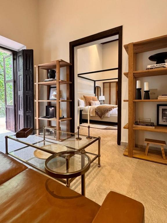 ein Wohnzimmer mit einem Glastisch und einem Bett in der Unterkunft Gran Faena in Aguascalientes