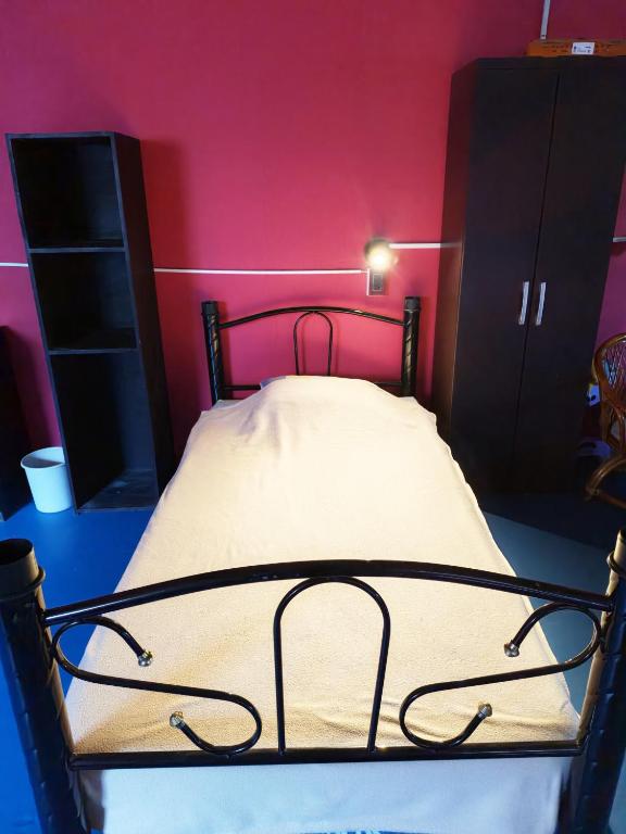 a bed in a room with a pink wall at Posada Doña Mari Aeropuerto in Mexico City