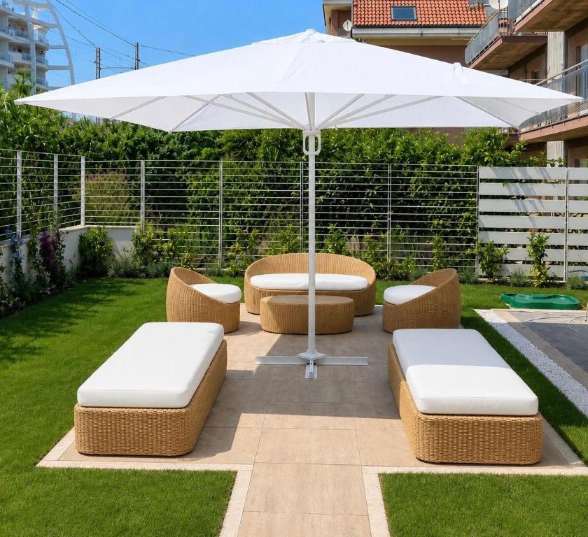 a patio with an umbrella and cushioned chairs and an umbrella at Approdo del Re in Grottammare