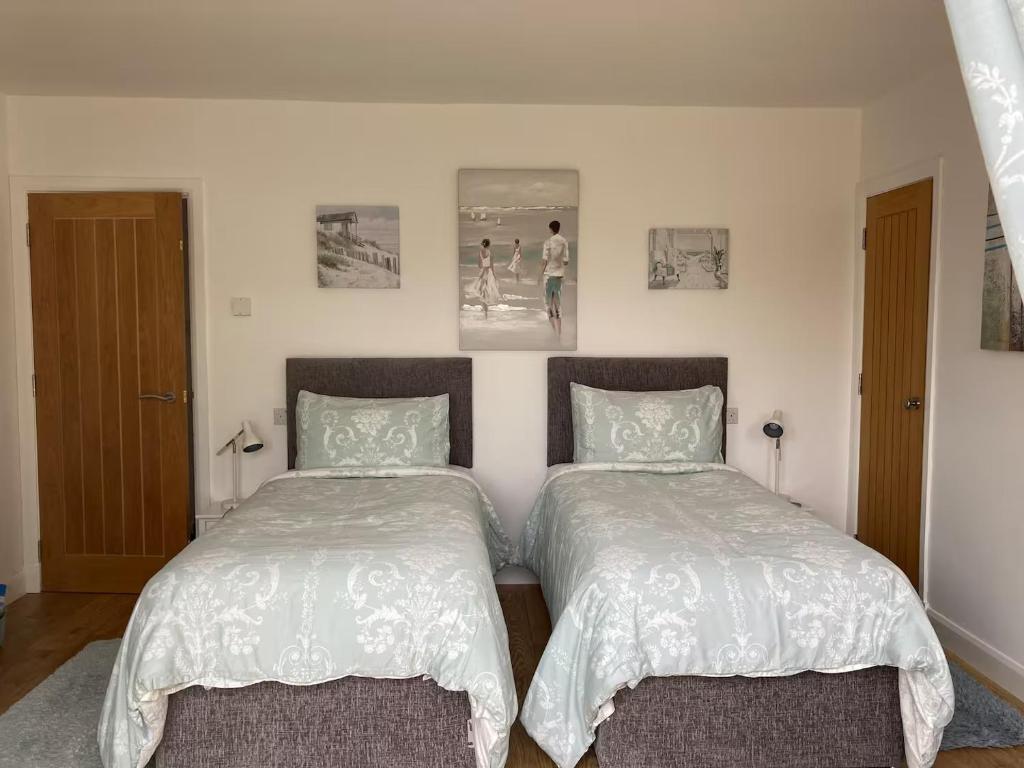 two beds sitting next to each other in a bedroom at Hawk Hill in Rosemarkie