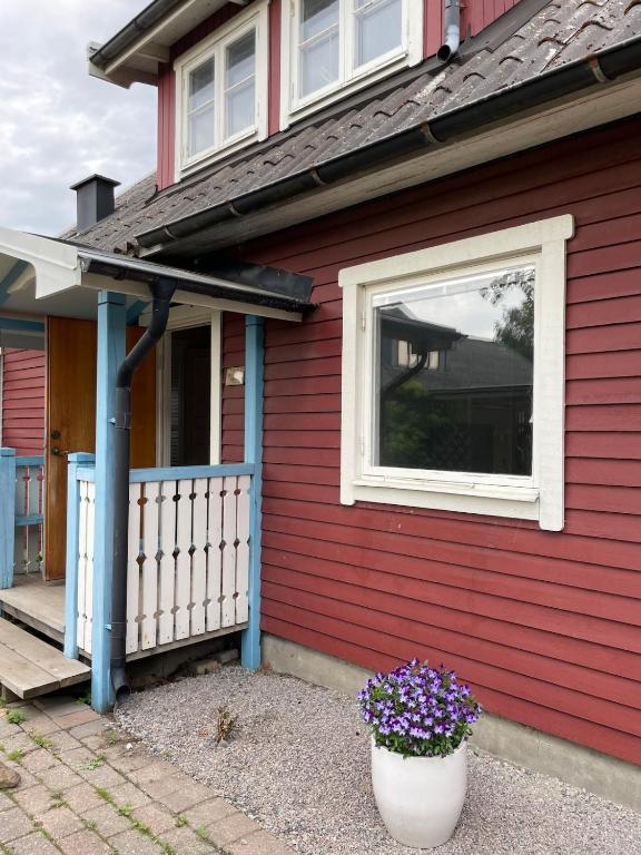 a red house with a window and a pot of flowers at Gästhus Vejbystrand in Vejbystrand