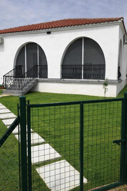 a house with two arched windows and a fence at Villa Archontiko in Mirodháton