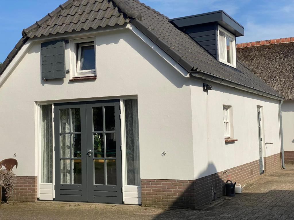 a white house with a black roof at For a wonderful outdoor feeling! in Zelhem