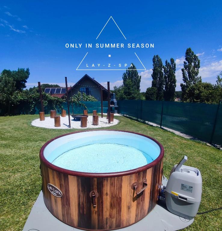 a hot tub in the middle of a yard at Guesthouse and Wellness VINEA in Spodnji Ivanjci