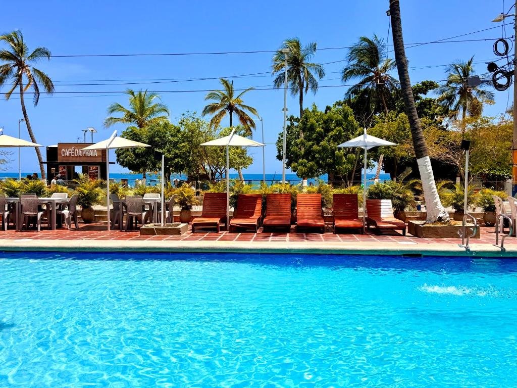 a pool at a resort with chairs and umbrellas at Hotel Rodadero Beach Blue in Santa Marta