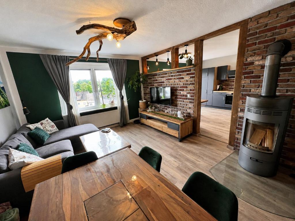 a living room with a couch and a fireplace at OESLAUER STUBE Gemütliches Apartment mit Kamin, Klimaanlage, Balkon, 3 Schlafzimmern, 2 Bädern, Modern, Familienfreundlich, Zentral, Vollausgestattet in Rödental