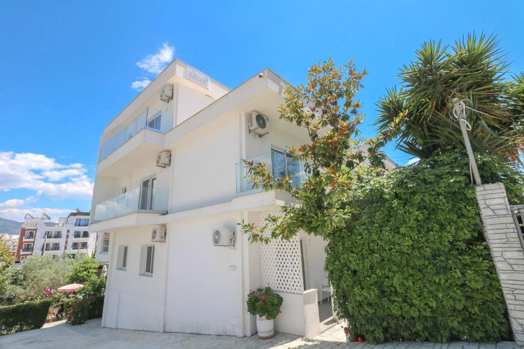 a white house with a tree in front of it at Vila Ori in Ksamil
