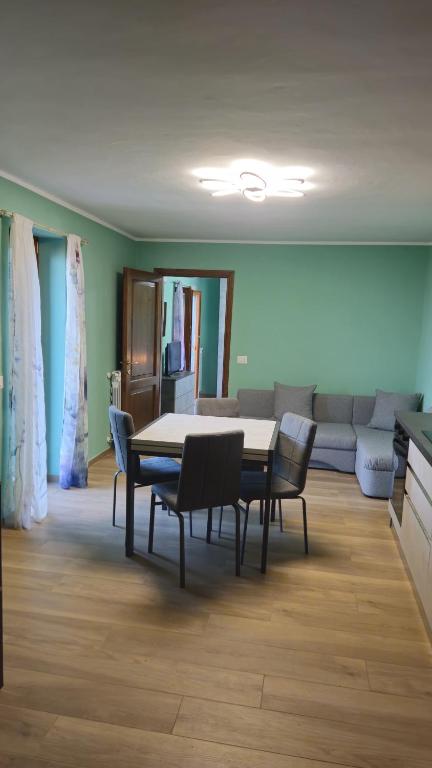 a dining room with a table and chairs and a couch at Casa Bella Vista in La Spezia