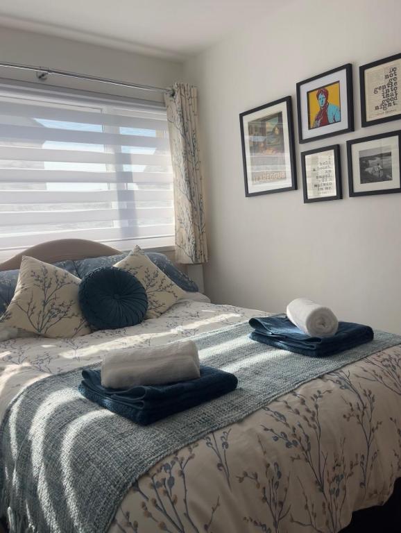 a bedroom with a bed with towels on it at Olive Mae - Cosy Room with private en-suite bathroom in Blackwood