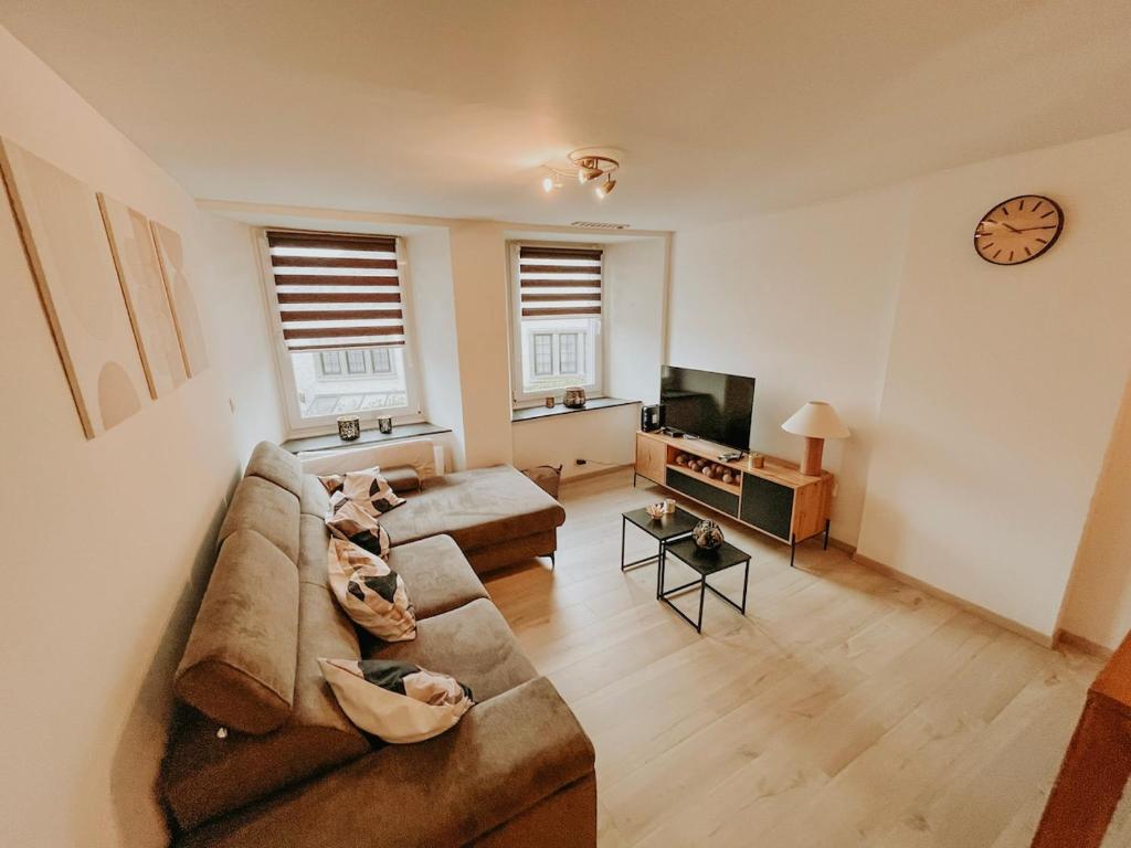 a living room with a couch and a tv at Chez Dubuiss in Houffalize