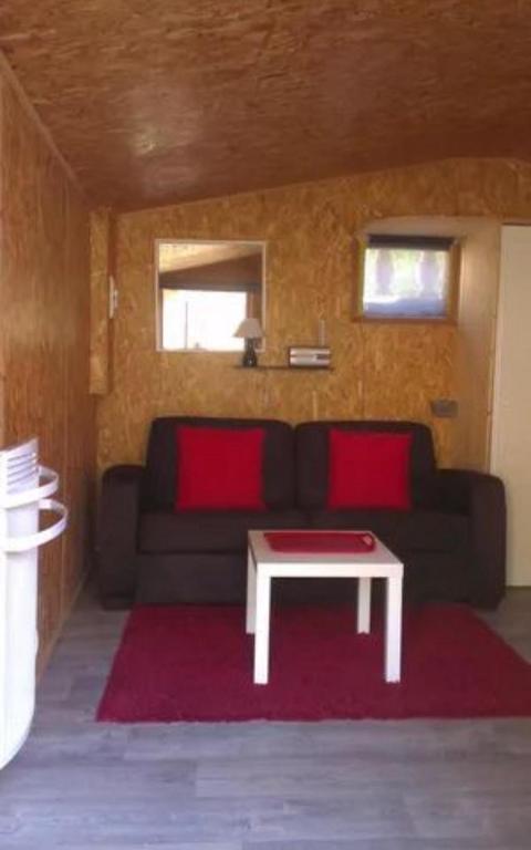 a living room with a black couch and a table at Chalet de la Grave in LʼEscarène