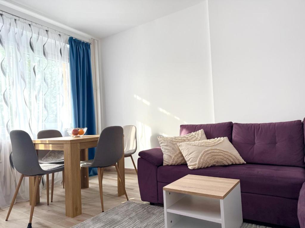 a living room with a purple couch and a table at Apartman Stankovic in Negotin