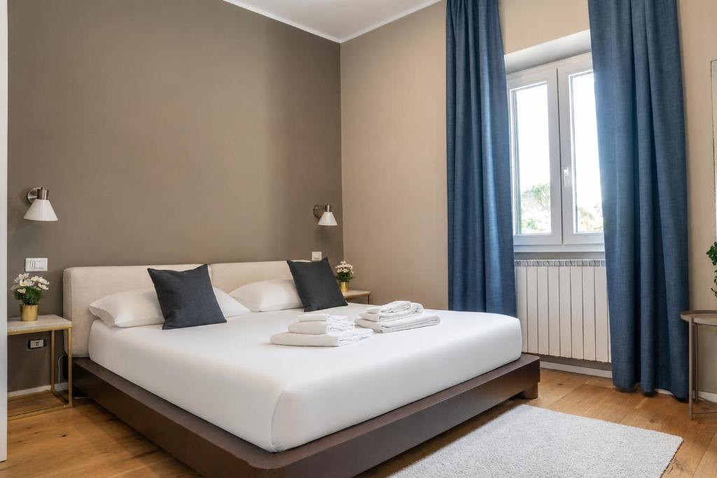a bedroom with a large white bed with blue curtains at Due Strade APT - Oltrarno Collection in Florence